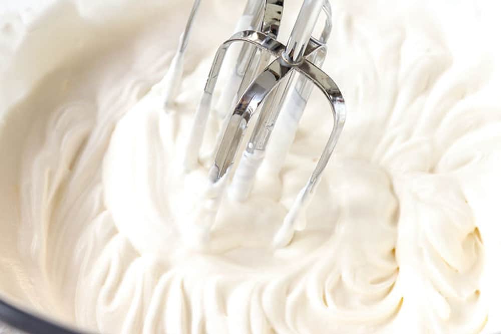 showing how to make lemon cheesecake by whipping cream to stiff peaks