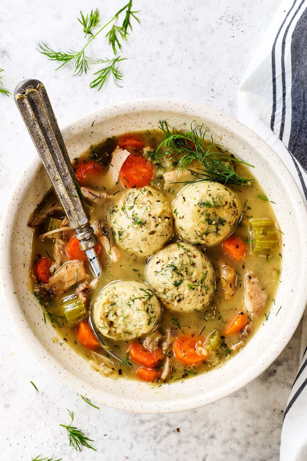 a bowl of matzo ball soup with matzo balls and chicken