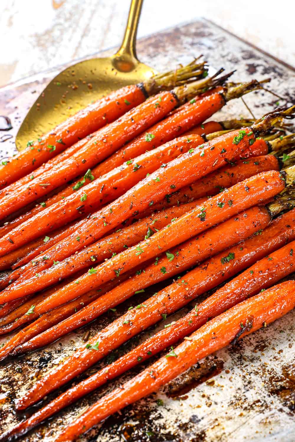 picking up oven roasted carrots with a spatula to serve