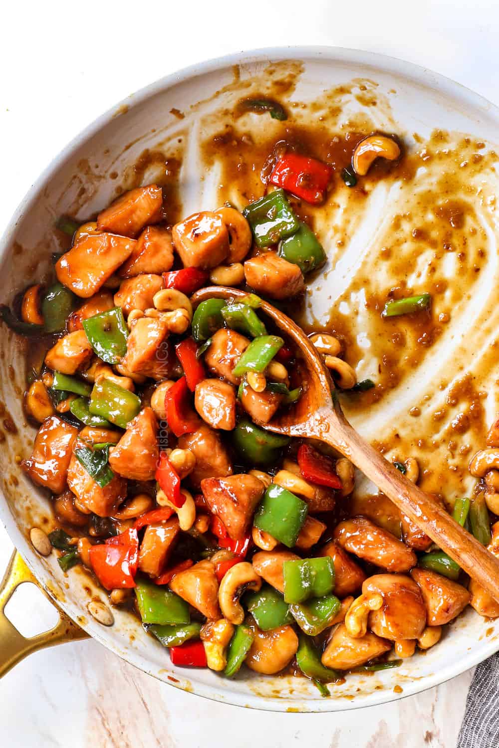 top view of half eaten cashew chicken in a skillet showing how saucy it is