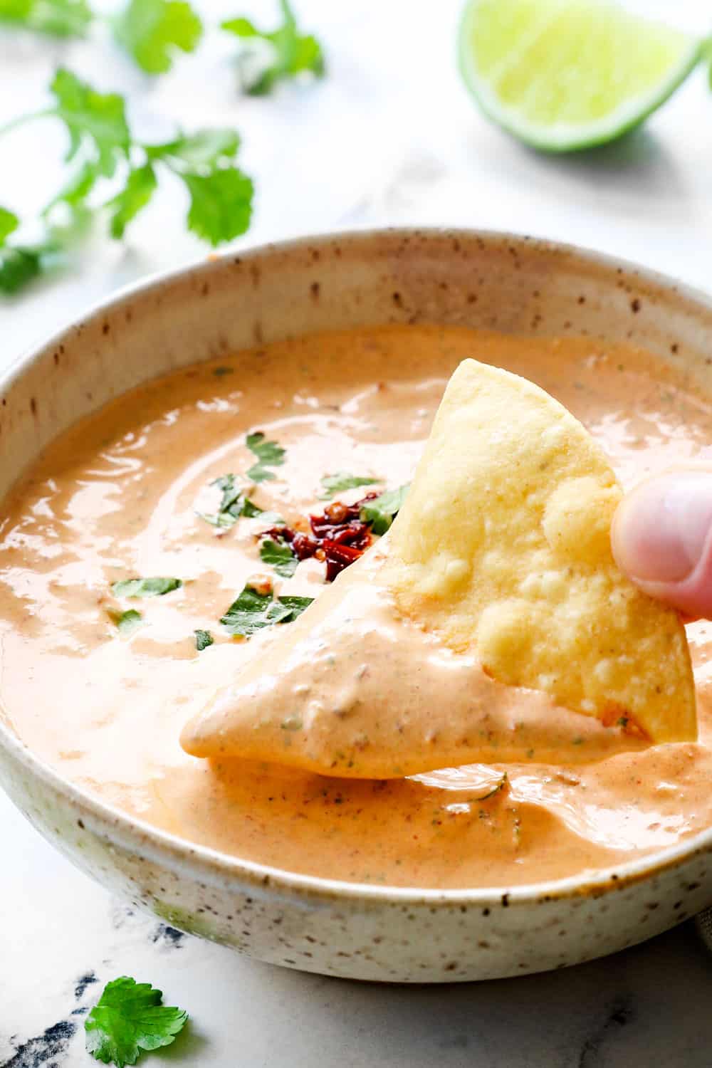 showing how to serve chipotle southwest sauce by dipping a chip in a bowl of the sauce