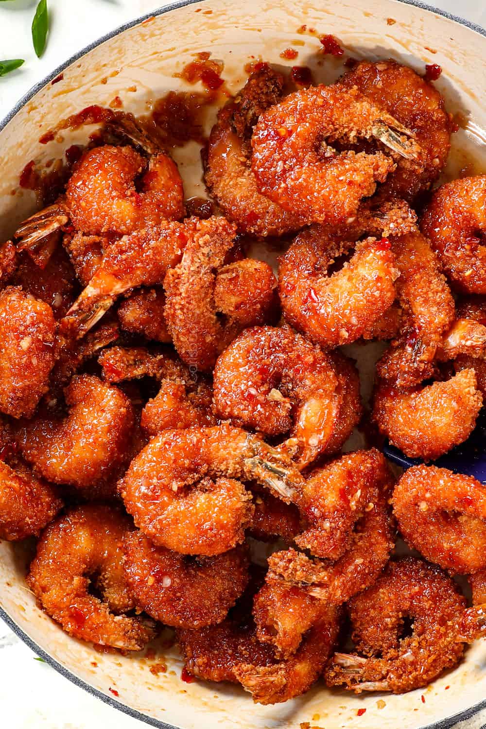 top view showing how to make firecracker shrimp by tossing it in firecracker sauce