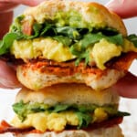 picking up a breakfast sandwich with cheese and eggs on muffins