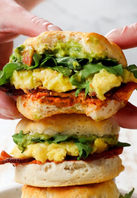 picking up a breakfast sandwich with cheese and eggs on muffins