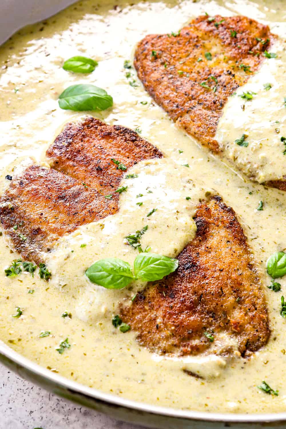 up close of pan fried tilapia in a pan showing how crispy it is