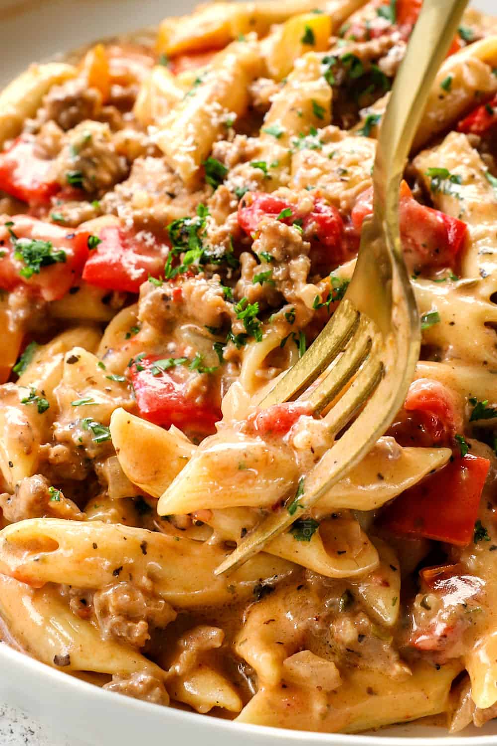 picking up Italian sausage pasta with peppers with a fork showing how creamy it is