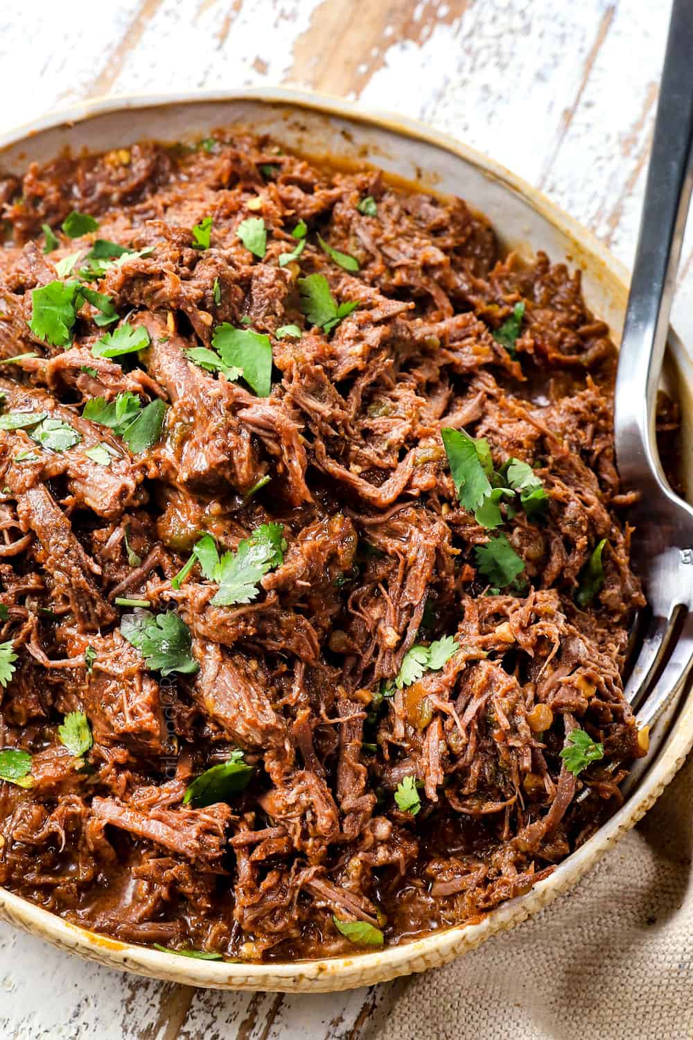 showing how to make taquito recipe by shredding beef in a bowl