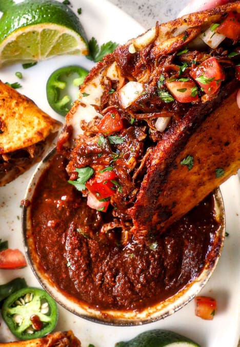 showing how to serve adobo sauce by dipping a taco in the sauce