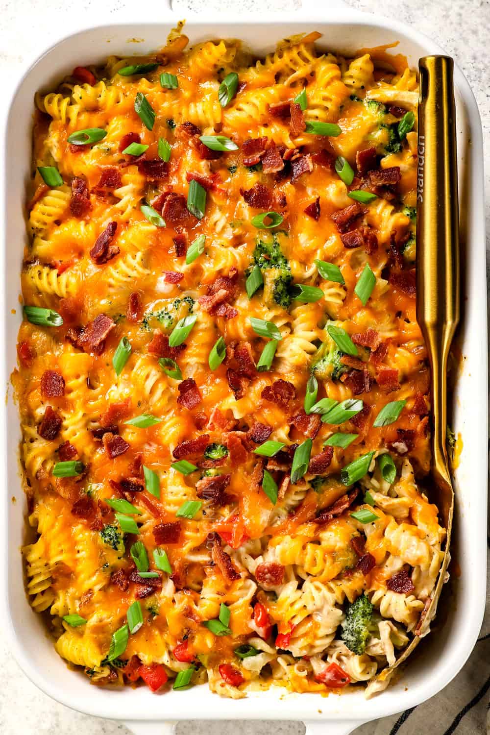 top view baking chicken bacon ranch casserole in a 9x13 dish with cheese