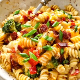 showing how to serve chicken bacon ranch casserole by adding to a bowl and topping with bacon