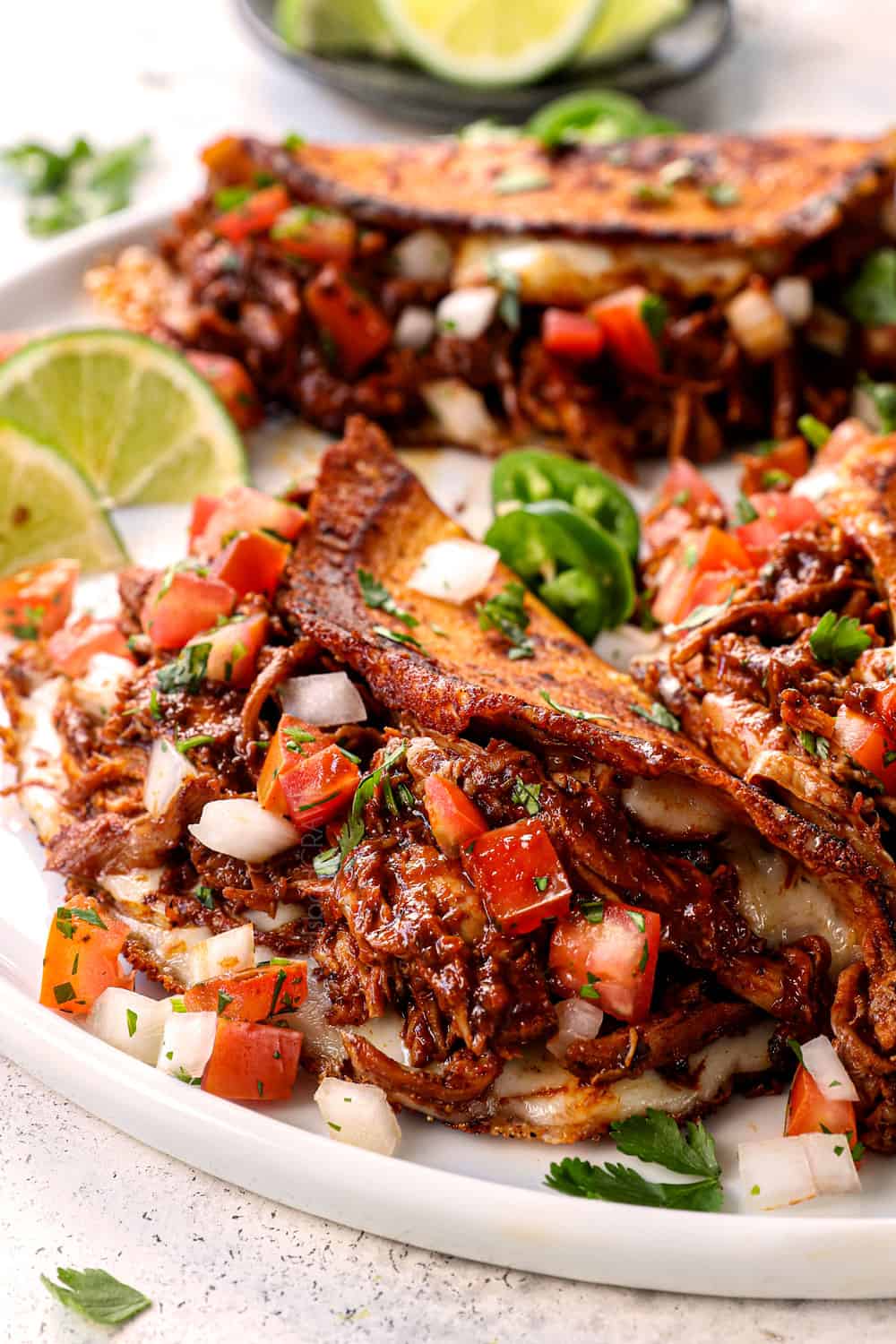 up close of chicken birria tacos on a plate showing how cheesy they are
