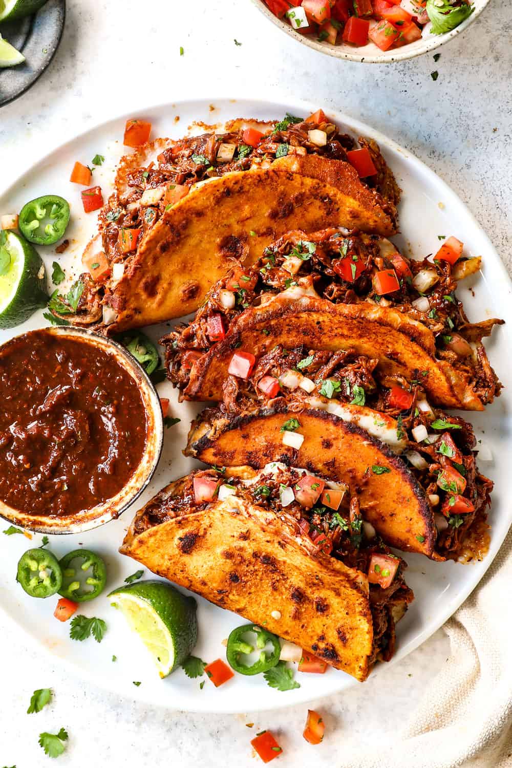 top view of chicken birria tacos served with cilantro and onion