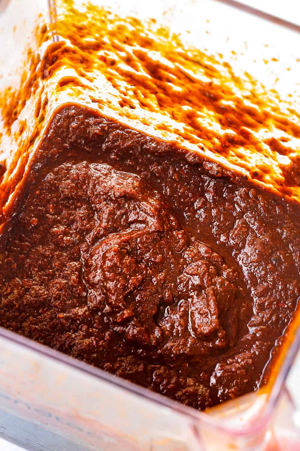 showing how to make chicken birria tacos recipe by blending chili sauce in a blender