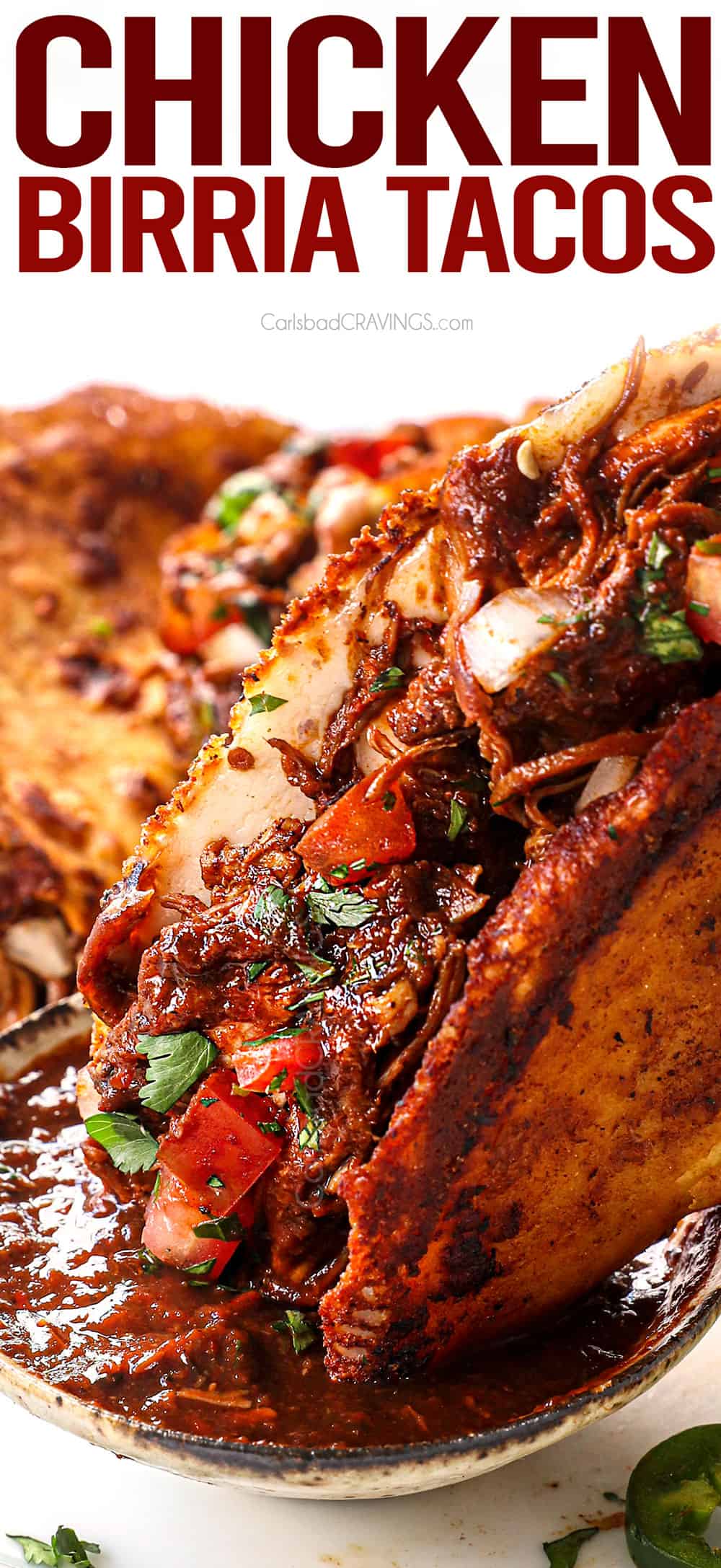 up close of dipping chicken birria tacos in the birria consume sauce