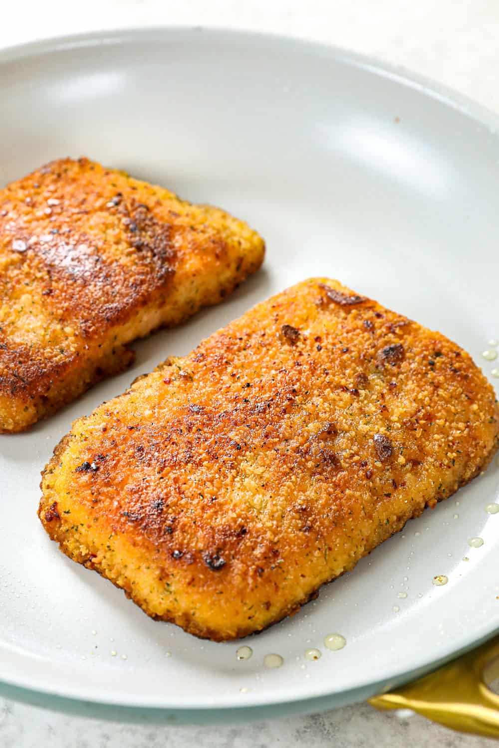 showing how to cook fish tacos by cooking salmon in a skillet until crispy