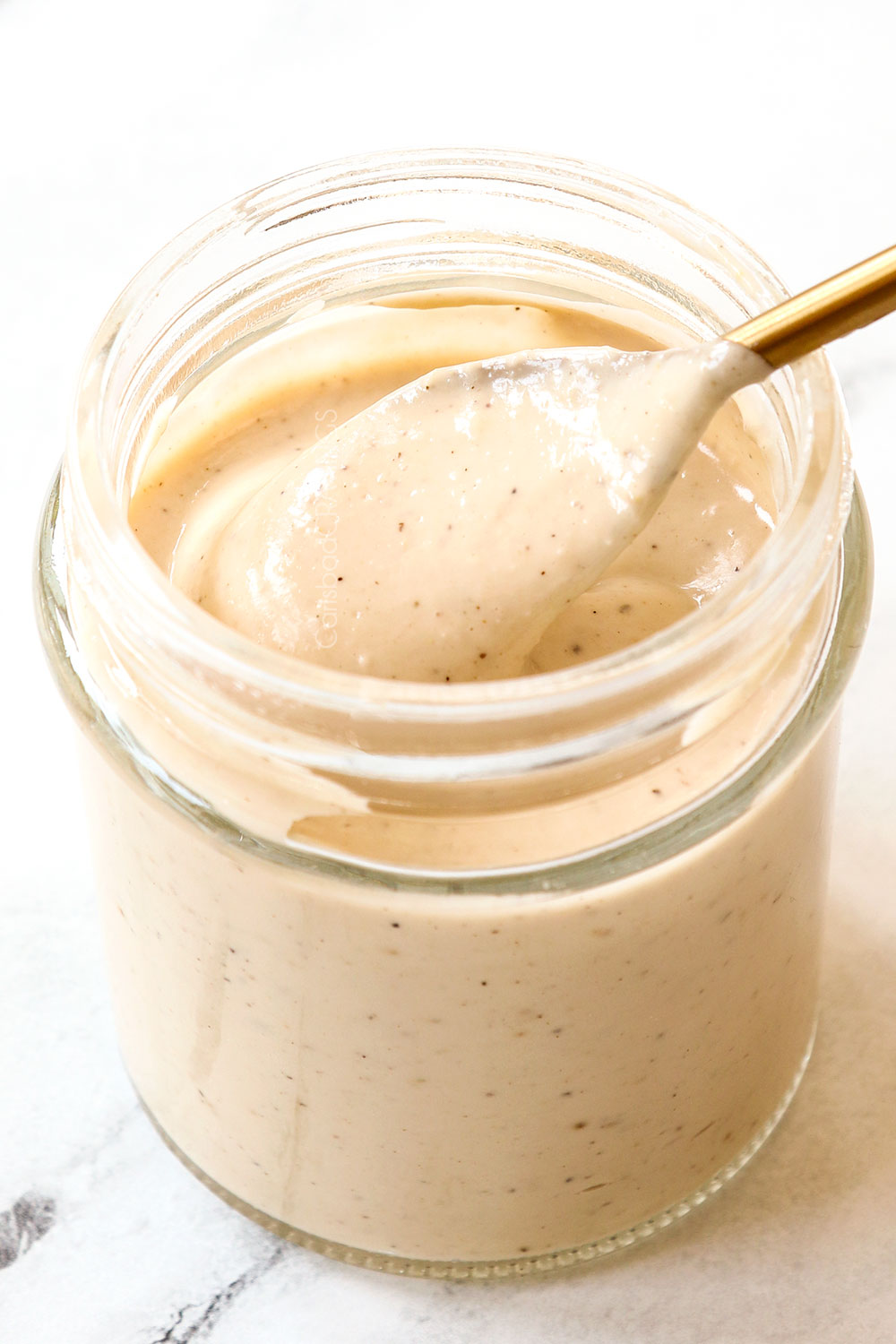 showing how to make Caesar Pasta Salad by whisking the homemade Caesar Salad Dressing ingredients together until smooth and creamy