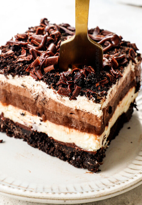 a fork taking a bite of of a slice of chocolate lasagna with Oreos and chocolate pudding