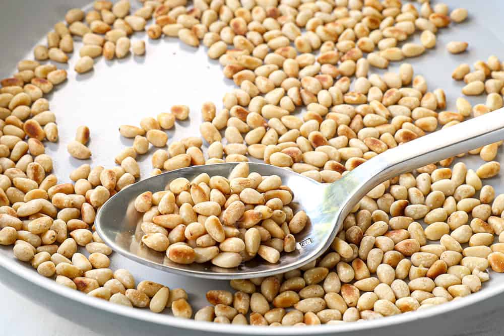 showing how to make pesto by toasting pine nuts in a skillet