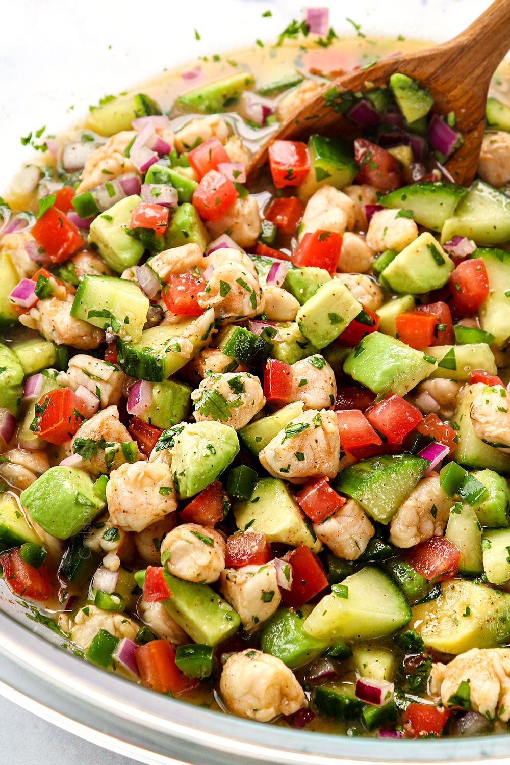 stirring clamato juice into shrimp ceviche recipe (ceviche de camaron)