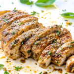 up close of sliced Italian Chicken on a cutting board showing how juicy it is