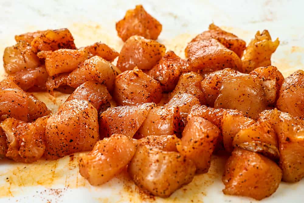 showing how to make lemon chicken orzo by seasoning chopped chicken breasts with paprika, salt, pepper