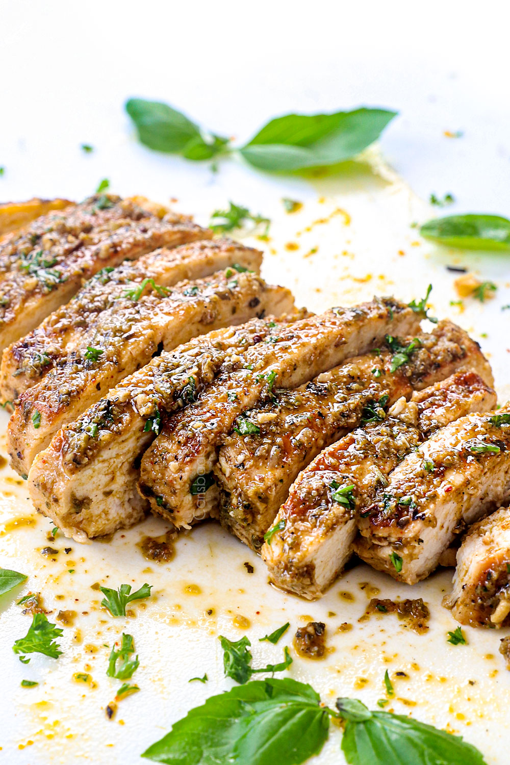 showing how to make Mediterranean Chicken Salad by cooking the chicken and then slicing