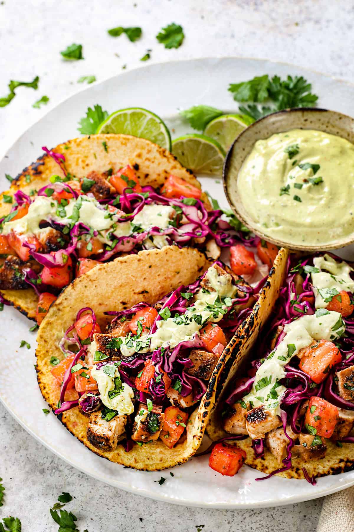 jerk chicken tacos lined on a plate with pineapple slaw