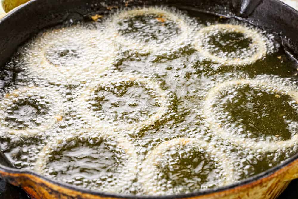 showing how to make BBQ pulled pork sandwiches by frying onion rings in hot oil to top the sandwiches