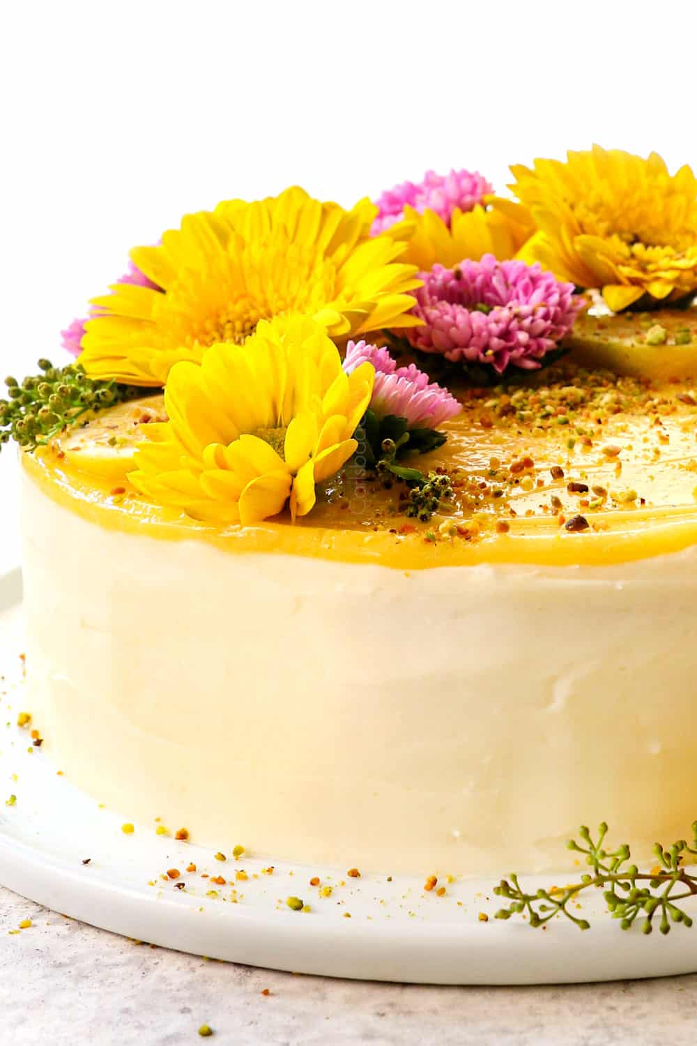 slide view of best lemon cake showing the smooth cream cheese frosting and top lemon curd