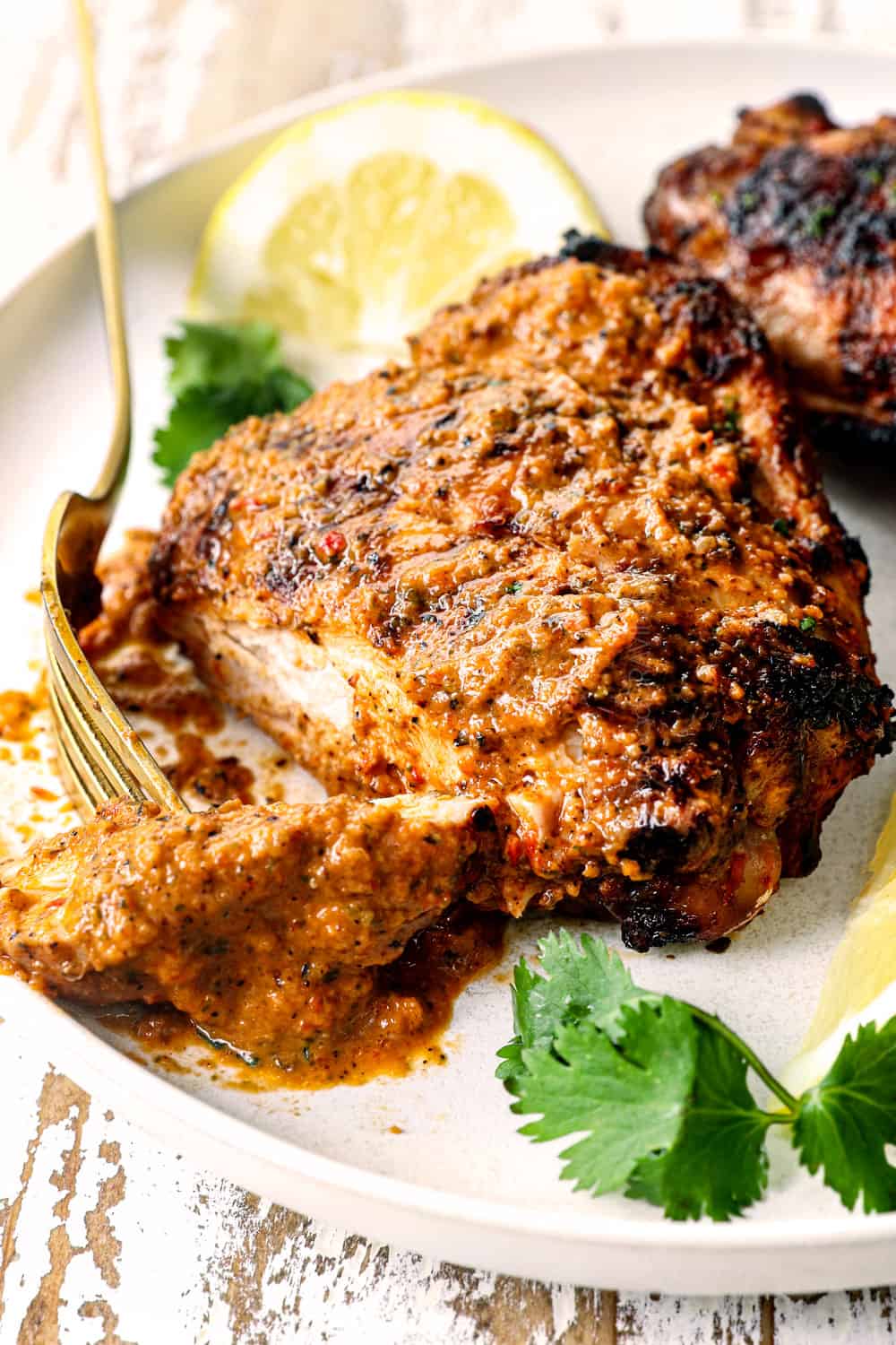 peri peri chicken recipe (piri piri chicken) brushed with peri peri sauce sliced on a plate showing how juicy it is