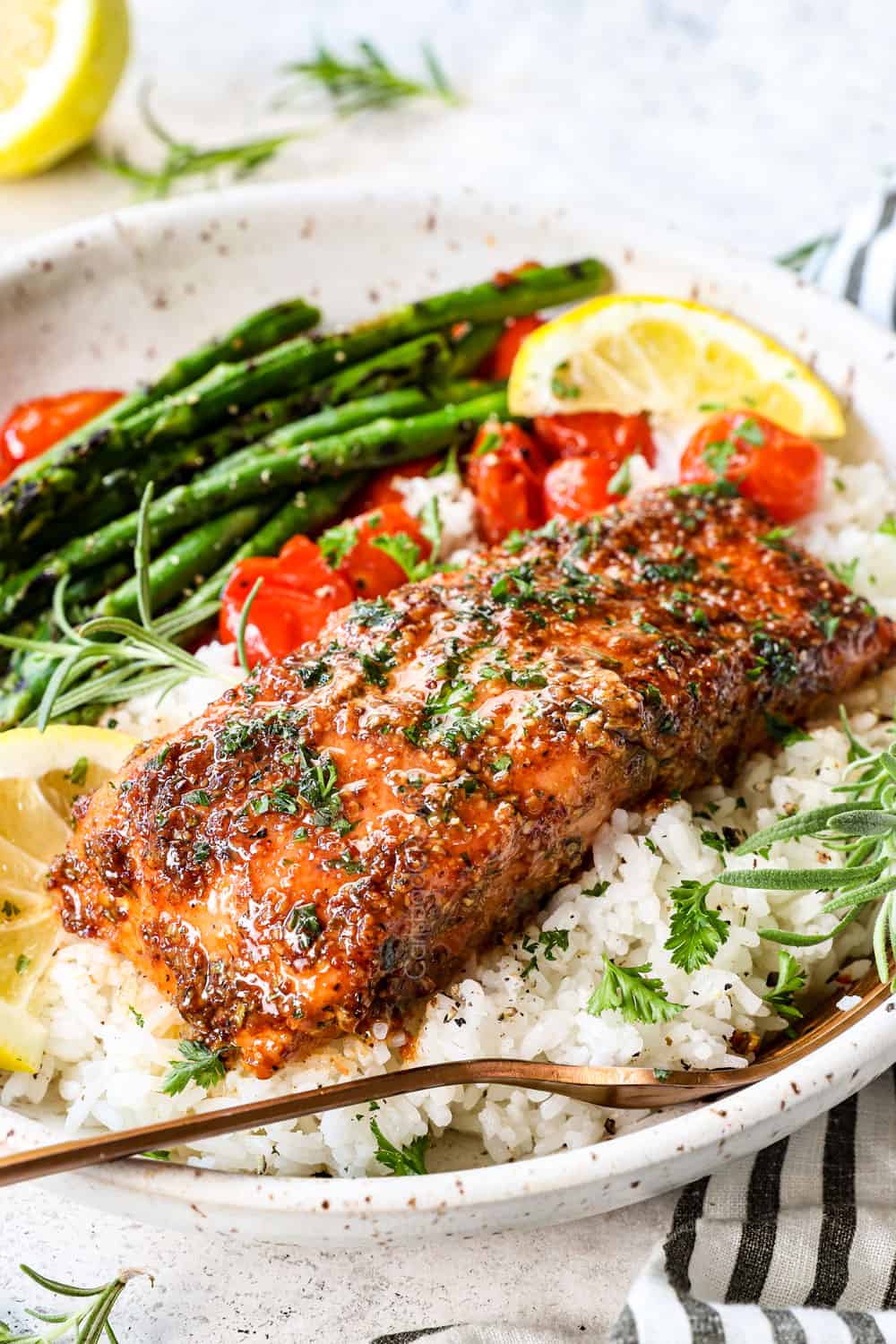 side view showing how to serve cedar planked salmon in a bowl with rice and vegetables garnished with parsley