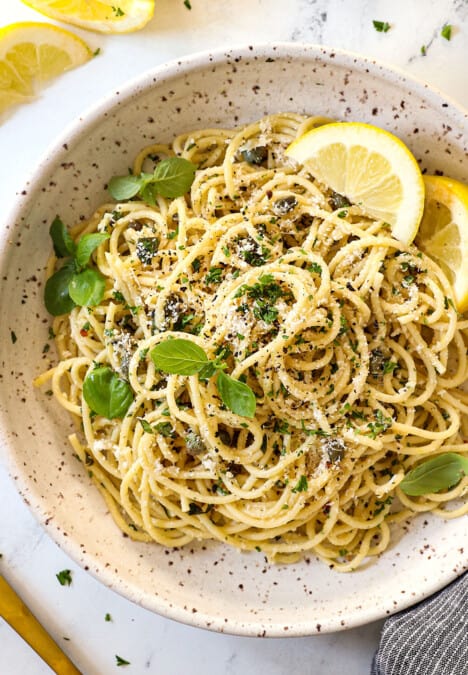 top view of lemon pasta recipe (pasta al limone) in a bowl garnished by Parmesan