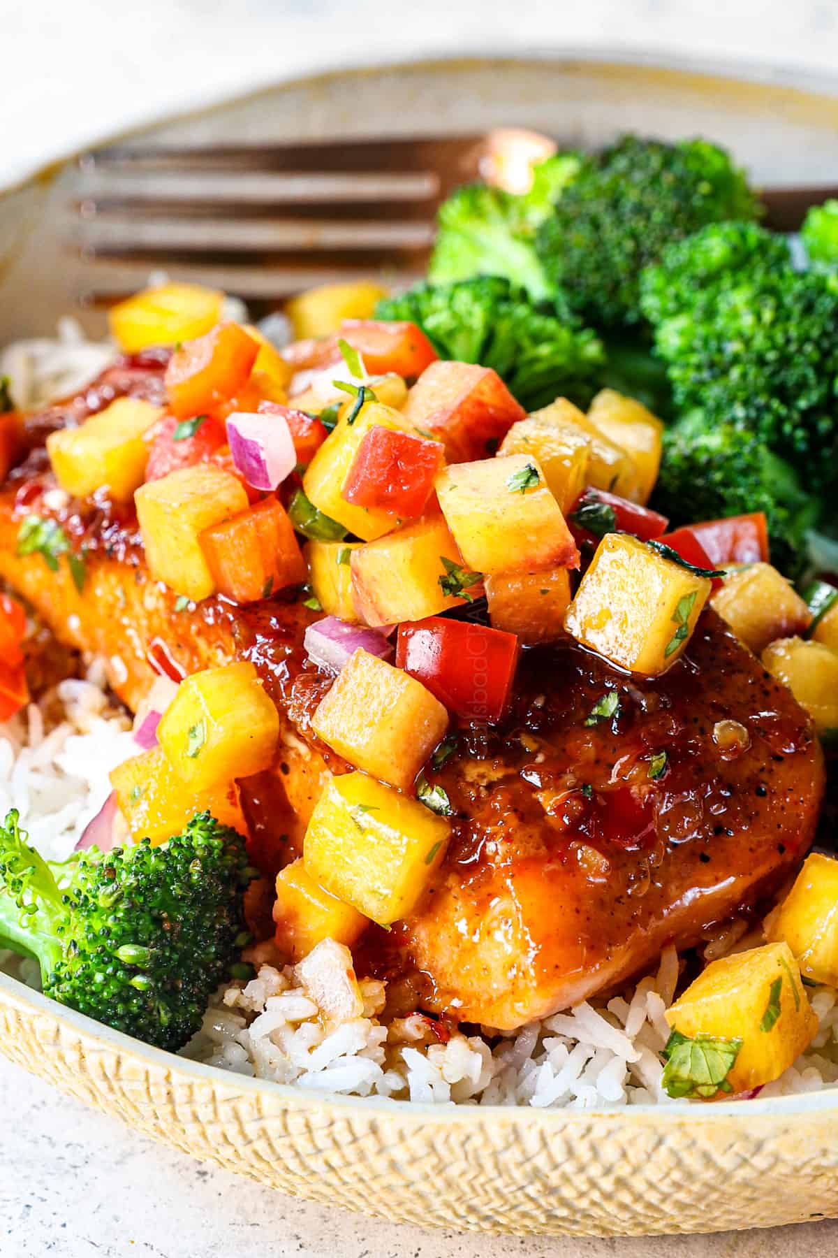 showing how to serve pan seared firecracker salmon by topping with peach salsa