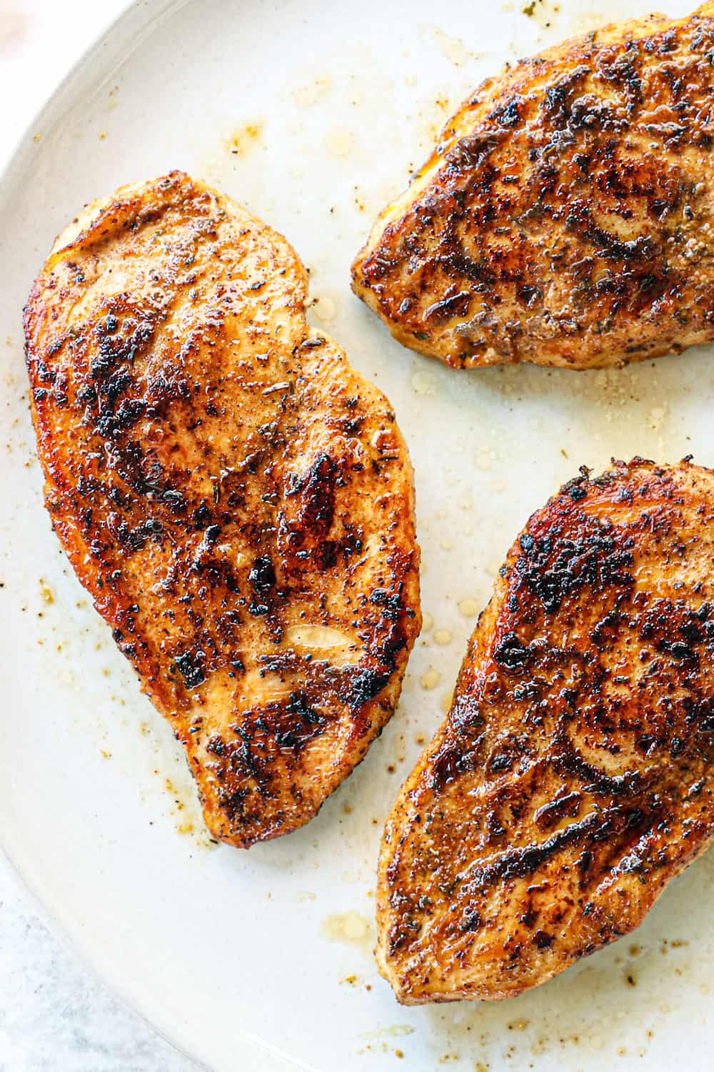 showing how to make jerk chicken pasta (Rasta Pasta) by seasoning chicken fillets with jerk chicken seasoniong