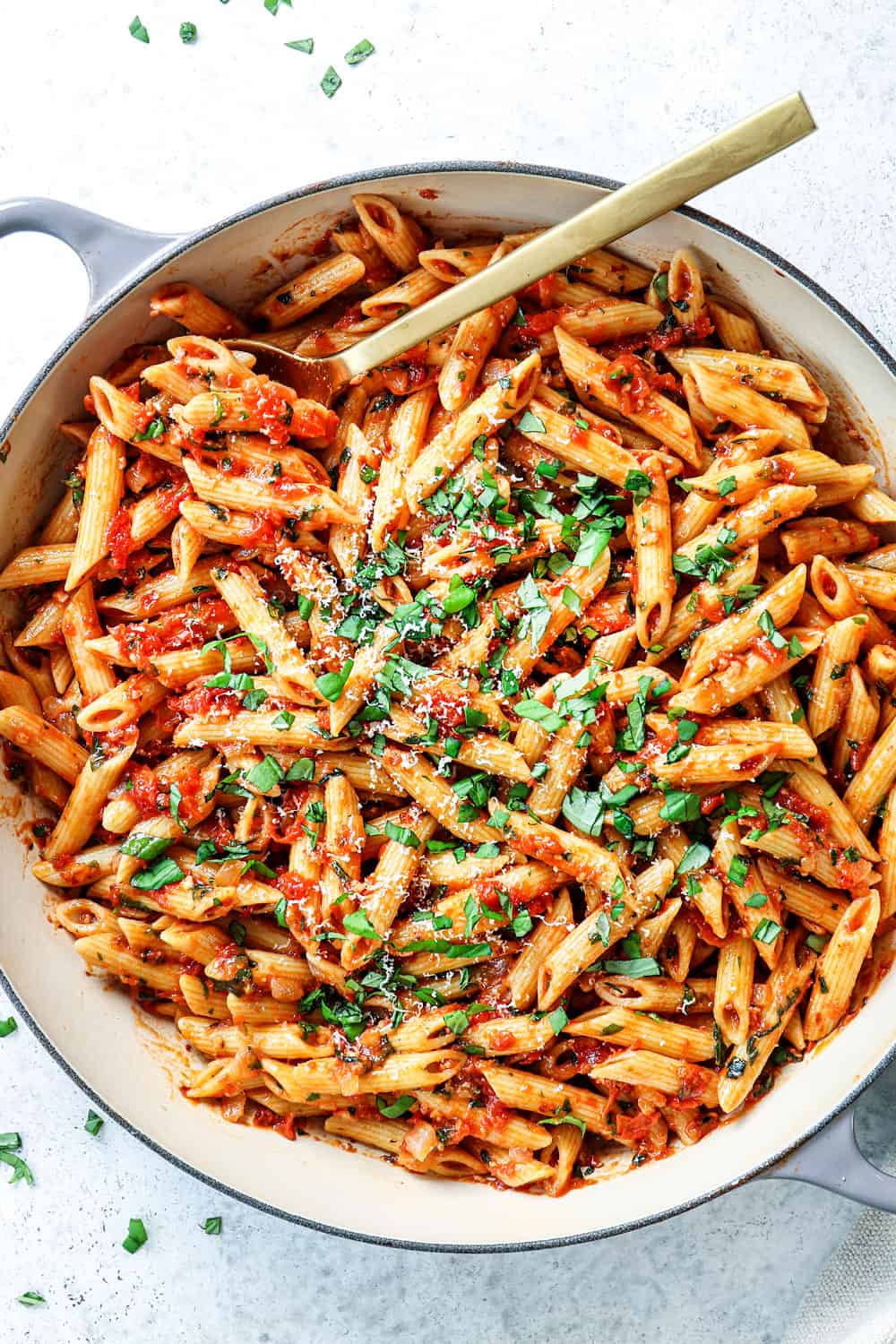 top view of Arrabiata sauce tossed with penne, basil in a pan