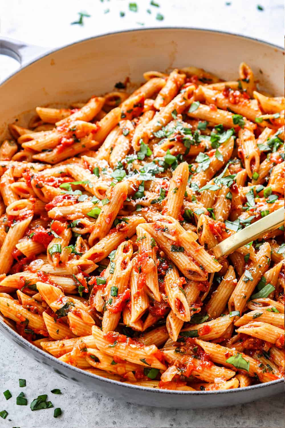 showing how to make penne arrabbiata my stirring the penne into the arrabiata sauce