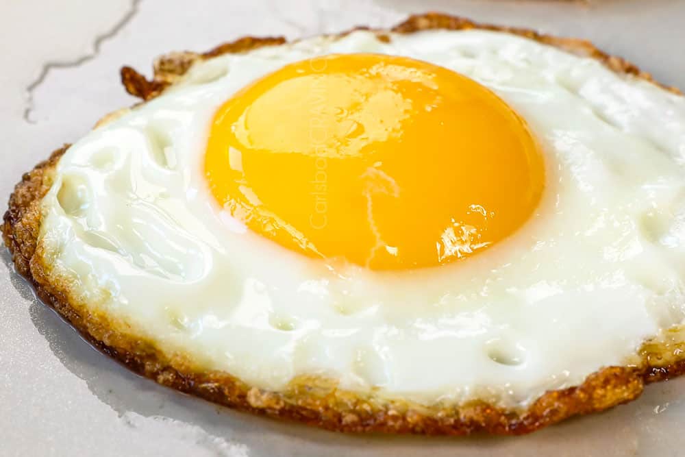 showing how to make loco moco recipe by frying eggs sunny side up