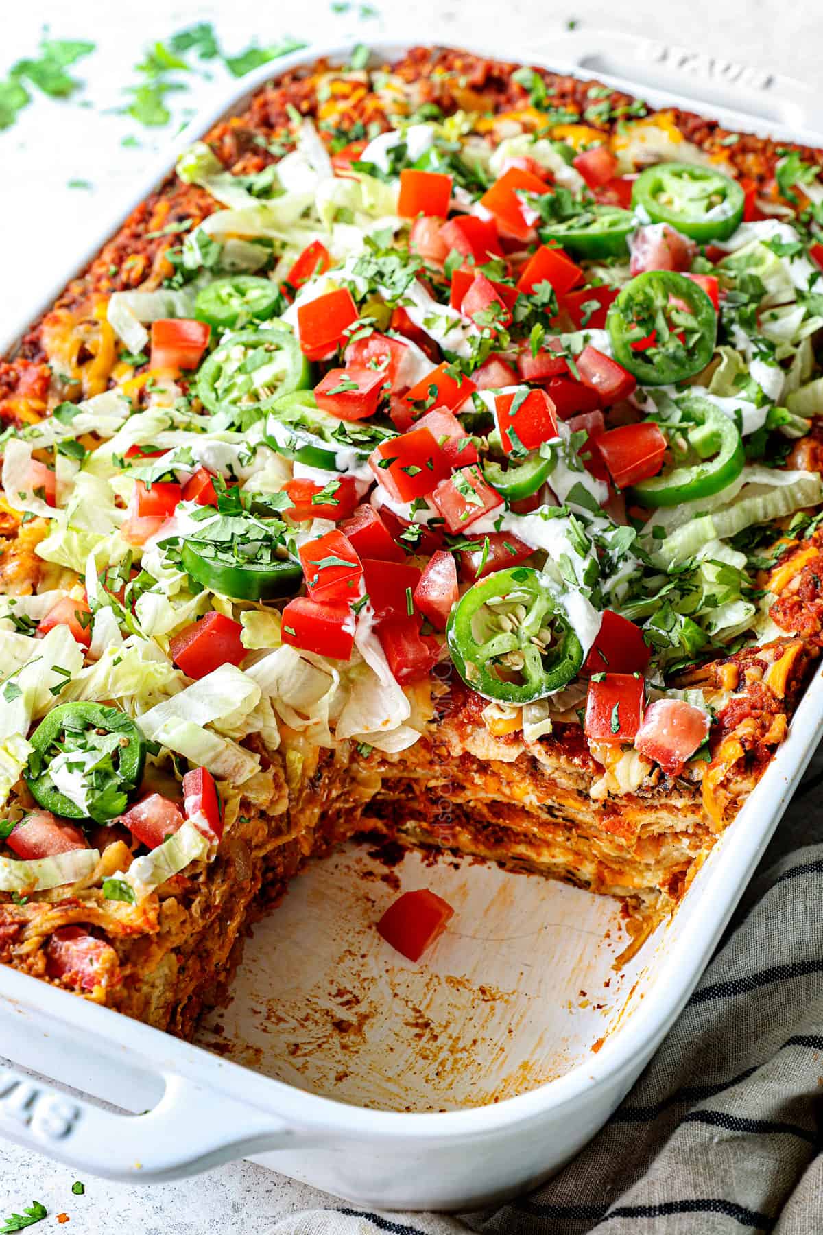 up close of taco casserole with a slice taken out showing all of the layers