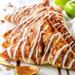 puff pastry apple turnovers lined in a row on a serving tray showing how puffy they are