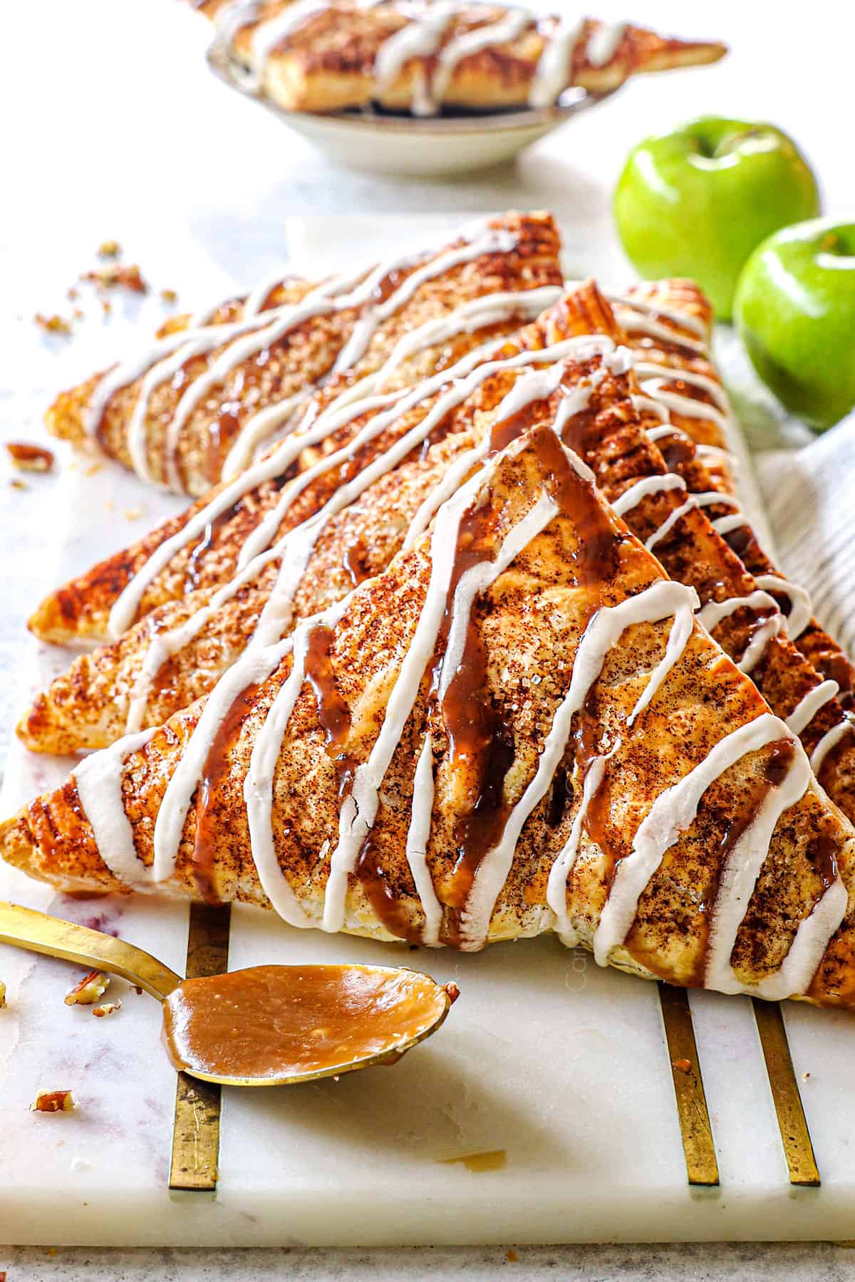 puff pastry apple turnovers lined in a row on a serving tray showing how puffy they are