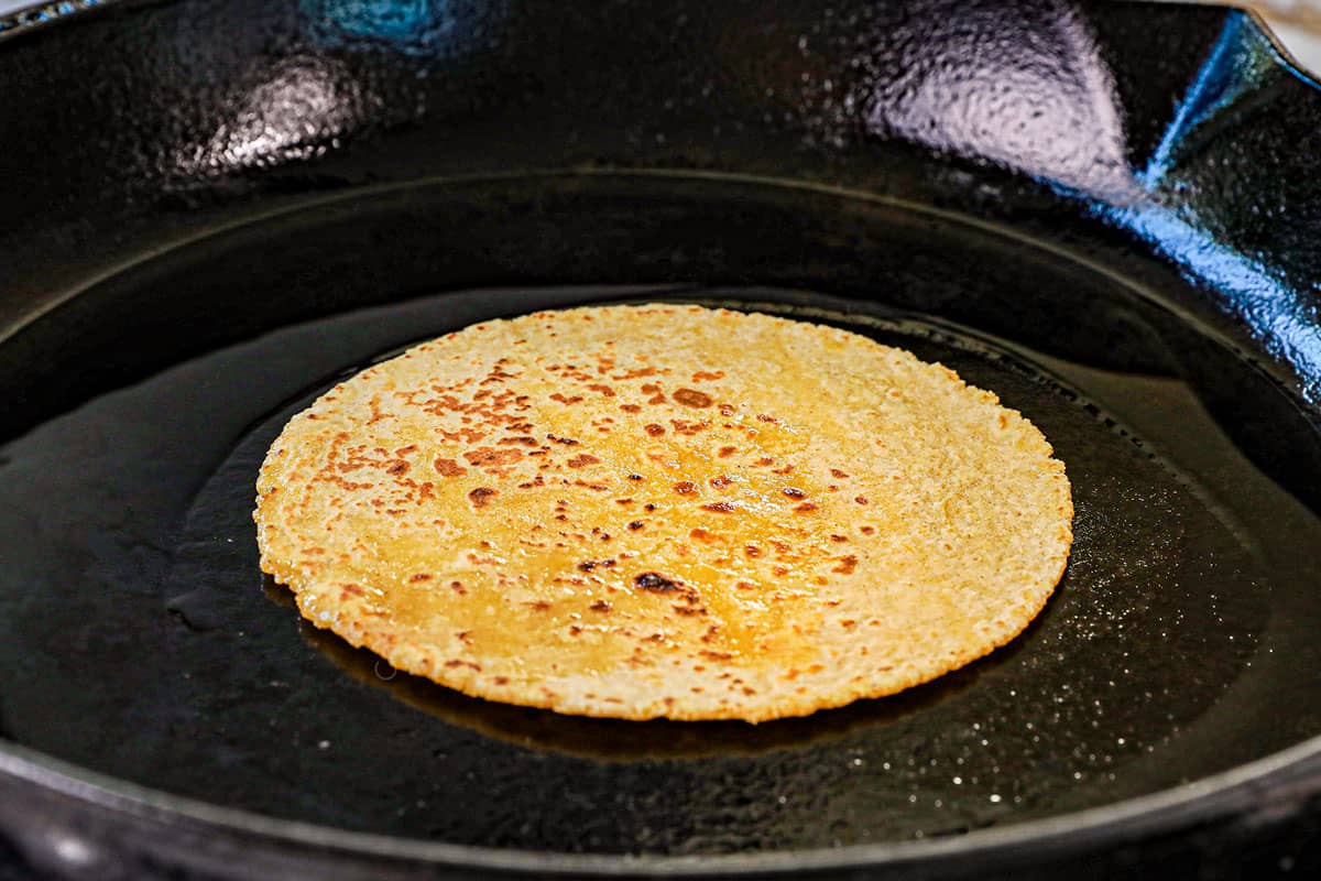 showing how to make chicken mole enchiladas by flash frying the tortillas