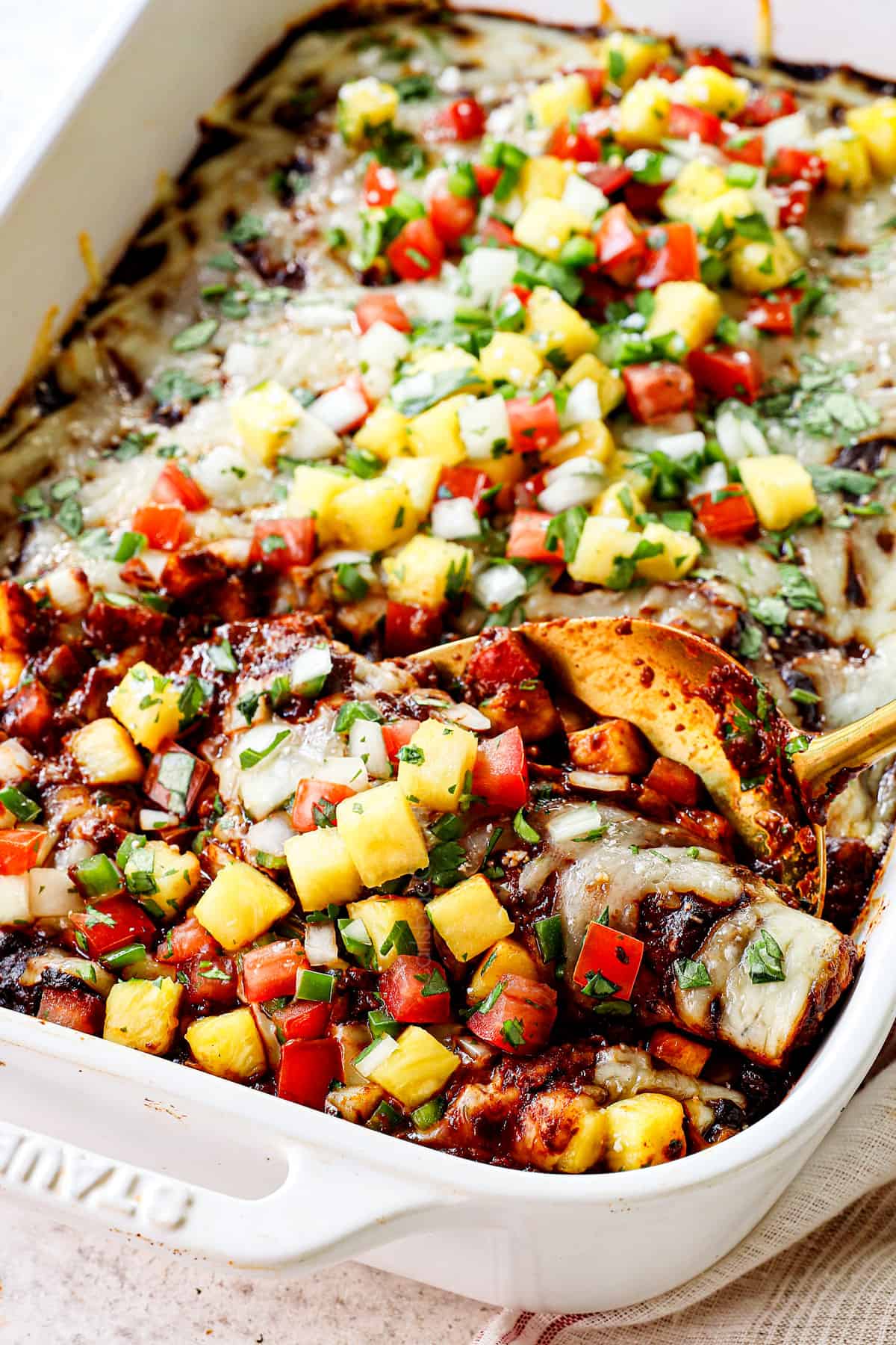 serving chicken mole enchiladas garnished by pineapple