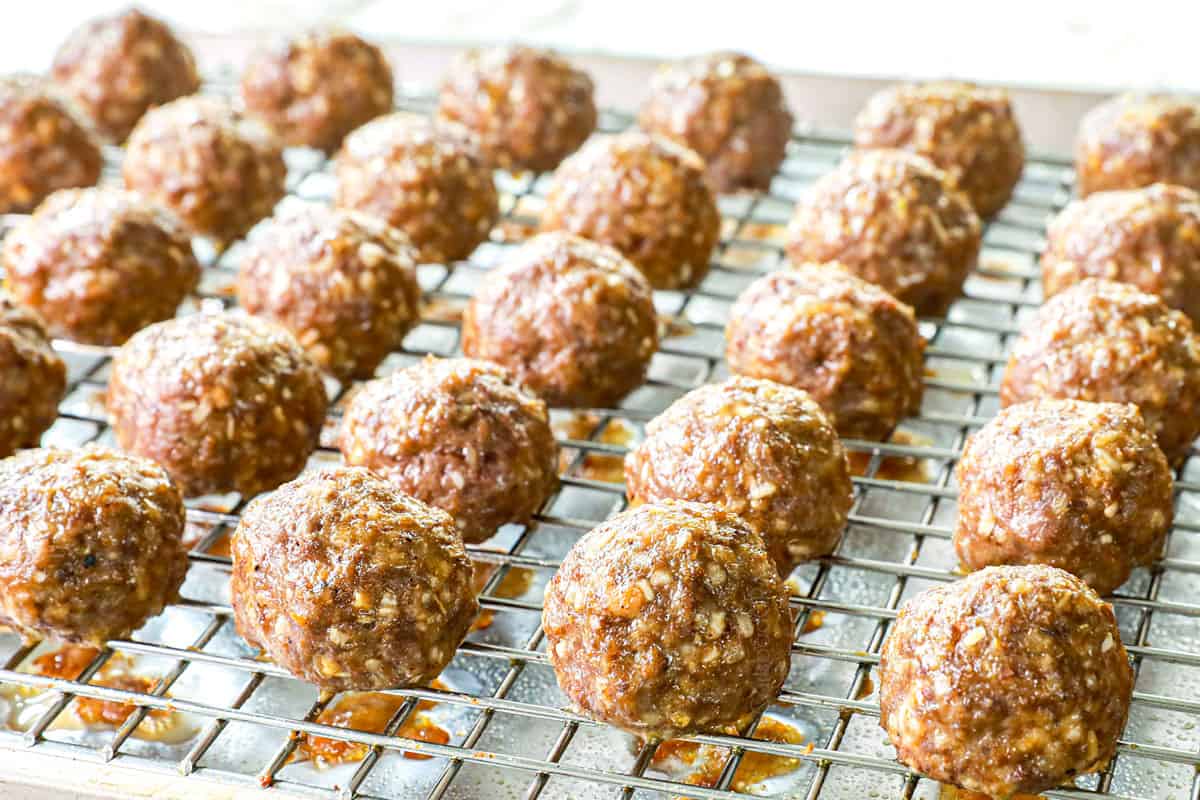 showing how to make grape jelly meatball recipe in the crockpot by baking meatballs in the oven before adding to the crockpot to finish cooking