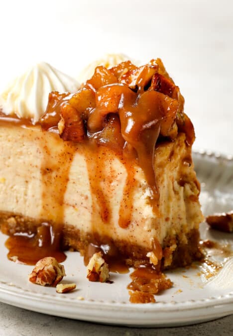 a slice of caramel apple cheesecake with a bite taken out showing how creamy it is
