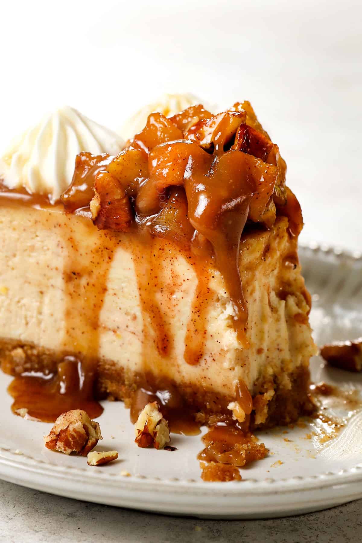 a slice of caramel apple cheesecake with a bite taken out showing how creamy it is