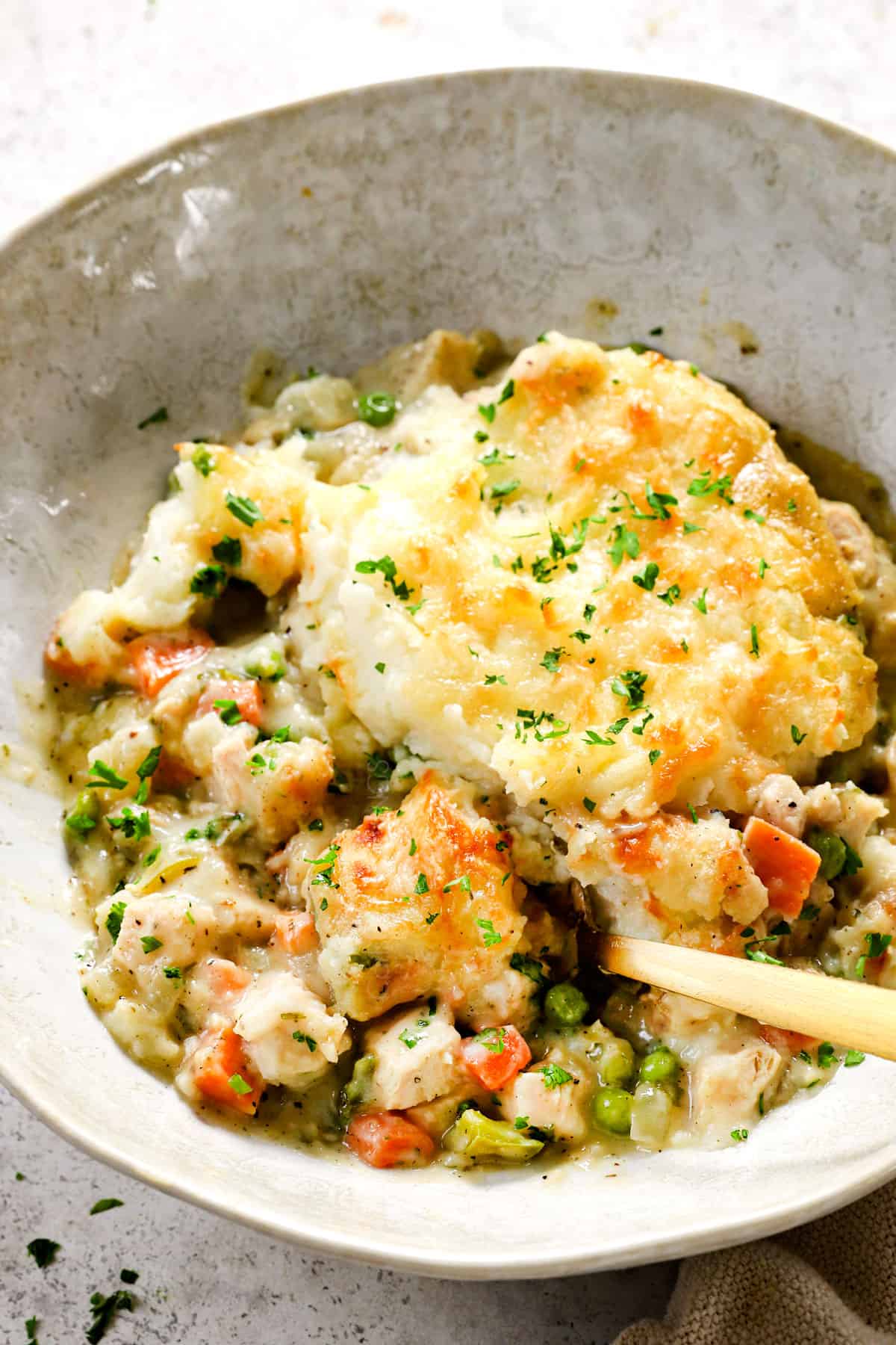 a bowl serving turkey shepherds pie garnished by parsley