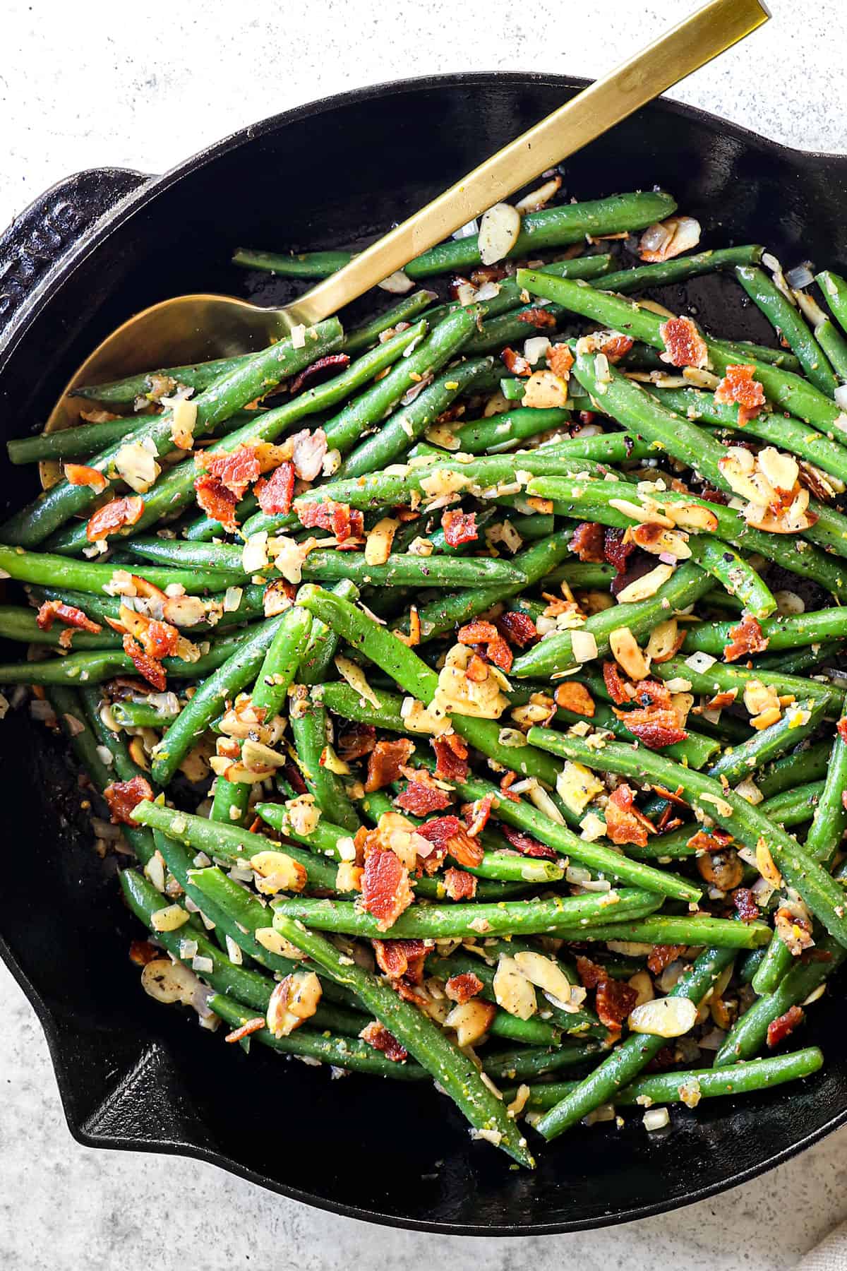 top view of making Green Beans Almondine by sautรฉing greens with butter, almonds, garlic and shallots