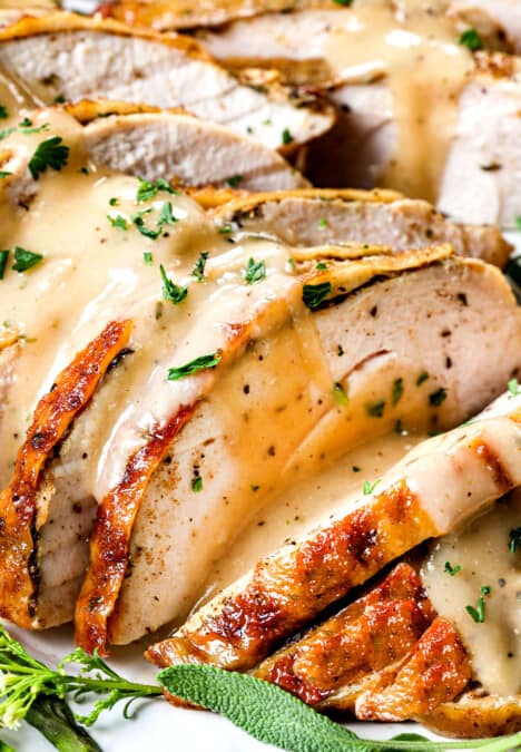 up close of roasted turkey breast with gravy showing how juicy it is