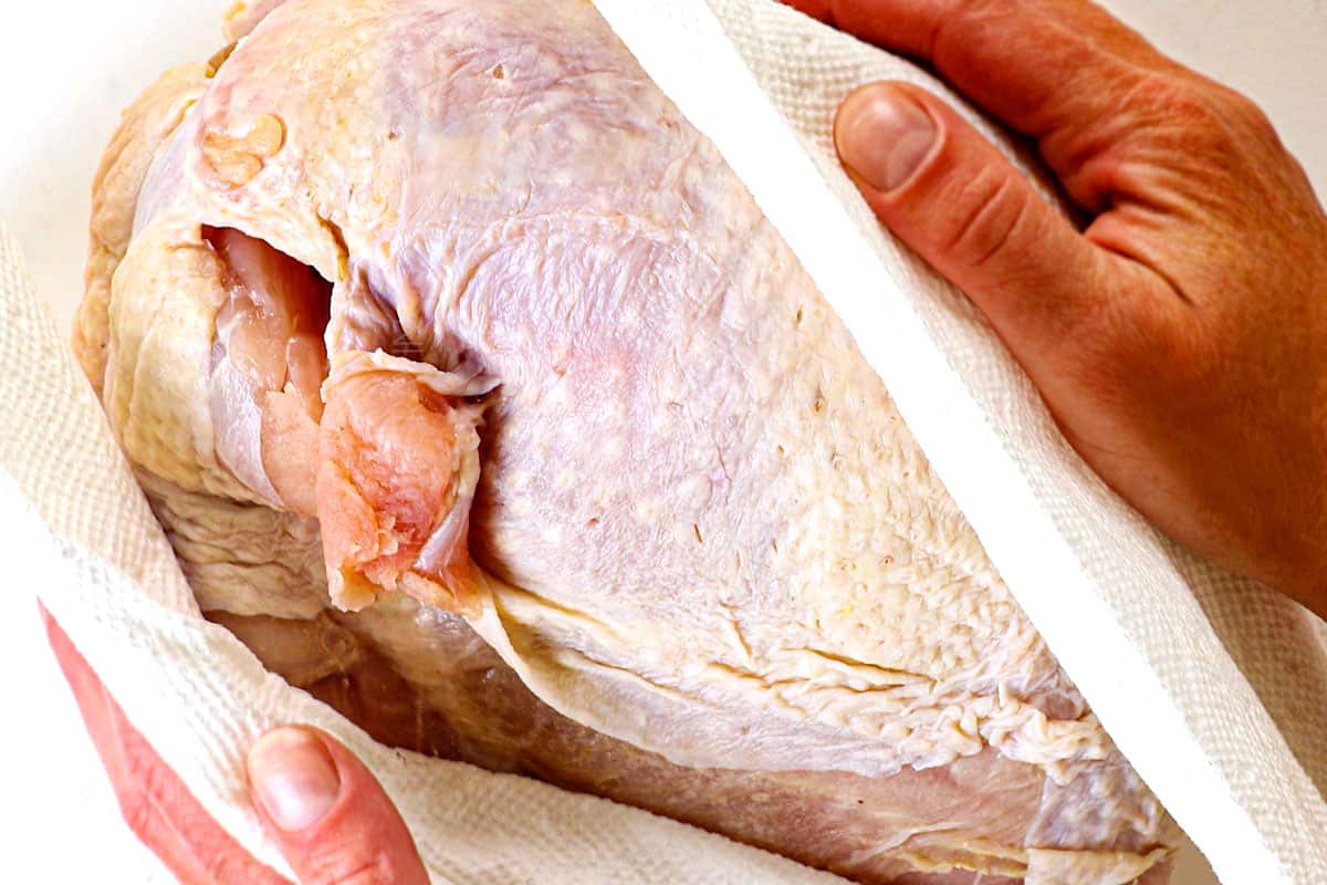 showing how to make roast turkey breast by drying the turkey breast with paper towels to crate crispy skin