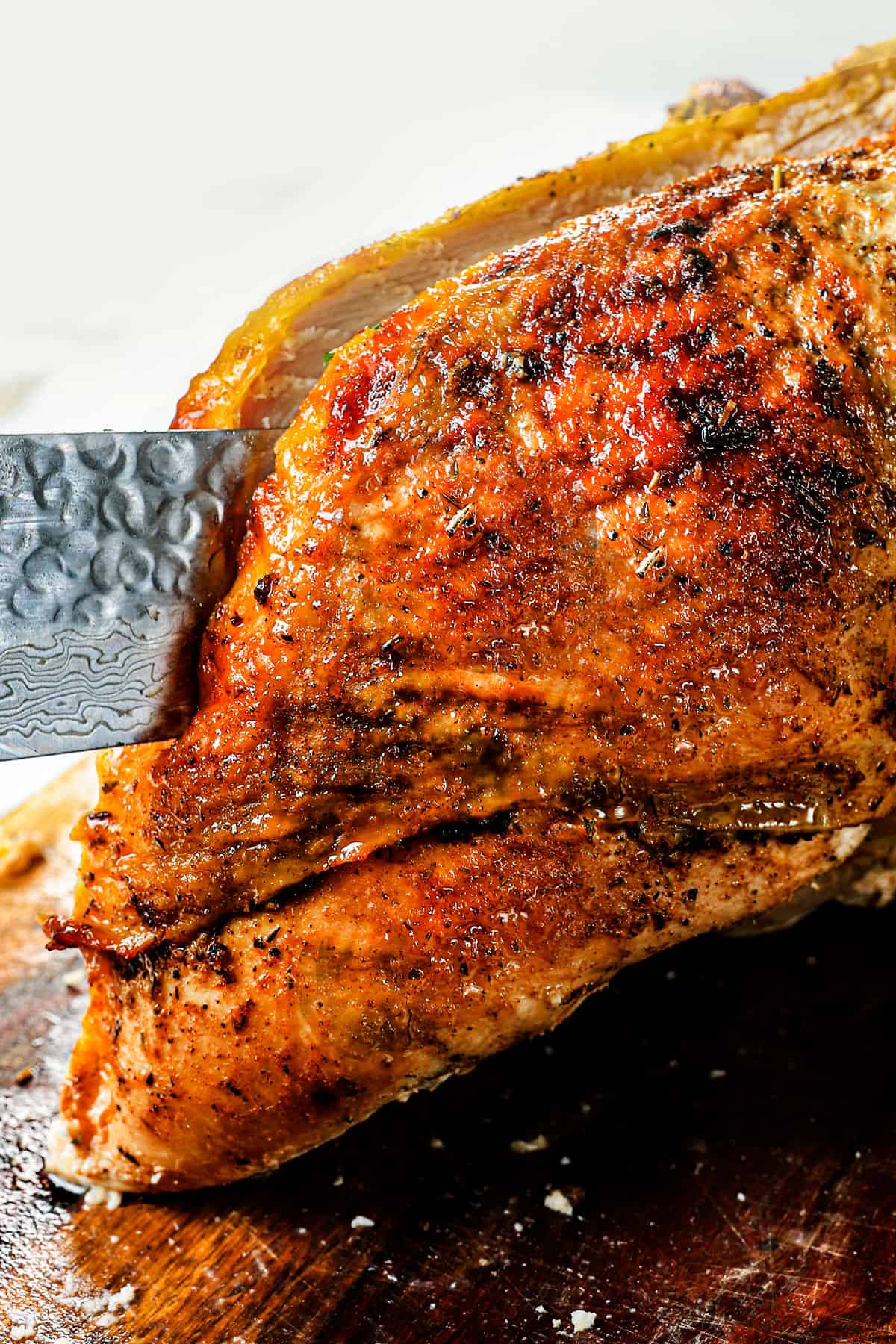 showing how to carve roast turkey breast by using a knife to cut close to the breast bone